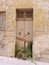 Vertical photo of closed shabby front door to abandoned house or production warehouse