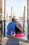 Vertical photo of couple sitting on pier in Venice