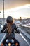 Vertical photo of a female motorcyclist skillfully moving through city streets on a powerful bike.