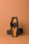 A vertical photo of a homemade small wooden open coffin against an orange background containing a black paper bat. Minimalist