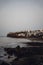 Vertical photo of an island shore, rocky sea coast. Dark and moody beach