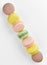 Vertical photo of macaroon. Colorful cakes macaron with pastel tones laid out in a strip from the corner of the frame to another