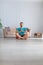 Vertical photo of a man meditating in home interior. Mental health concept.