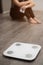 Vertical photo of measuring scale amid distressed upset girl. concept that you need to measure yourself holding chocolate