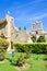 Vertical photo of medieval Bellapais Abbey in Turkish Northern Cyprus. Captured with the adjacent park and with blue sky.