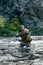 Vertical photo of a mercenary military soldier during a sabotage mission behind enemy lines - he stands knee-deep in the