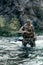 Vertical photo of a mercenary soldier crossing the river after the completion of the sabotage operation. Saboteur