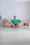 Vertical photo of a middle-aged man meditating in home interior.