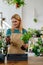 Vertical Photo Of Midlife Blonde Enthusiast Joyfully Engaged in the Repotting Process, Infusing Each Moment with