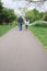 Vertical photo of a multicultural couple walking on a footpath in Figgate Park in Edinburgh in spring time. Biracial family