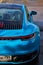 Vertical photo of Porsche 911 Carrera 4S & x28;Miami Blue& x29; 992 Sports with space for text rear view of trunk and headlights