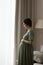 Vertical photo of profile pregnant woman in dress touching belly