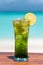 Vertical photo refreshing mojito mocktail on wooden table ocean background at the beach