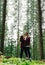 Vertical photo  romantic couple man and woman while walking in a mountain forest on a climb up the mountain stand in the arms of