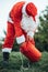 Vertical photo of Santa Claus crouched with his hand inside his red bag taking something from inside