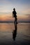 Vertical photo of a silhouette of a moving girl walking on the water