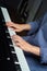 Vertical photo. Tender female hands play the piano. Photo without a face.