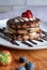 Vertical photo of vegan blueberry pancake stack, made with high protein kamut flour and flaxseeds, with coconut cream topping.