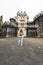 vertical photo of a woman in front of a castle