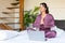 Vertical photo of a woman yoga practicing in bed in front of laptop monitor.