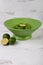 Vertical photo in wooden bowl filled with green sour lime
