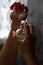 Vertical photo of young female hands with faceted bottle of perfume. Testing eau de parfum toilette water.