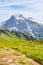 Vertical photography of beautiful Swiss Alps in summer. Famous mountains Jungfrau, Eiger and Monch in the background. Hiking path