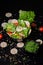 Vertical picture of a bowl of salad with crackers and vegetables under the lights