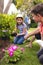 Vertical picture of caucasian family spending time together in the garden, planting