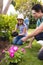 Vertical picture of caucasian family spending time together in the garden, planting