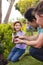 Vertical picture of caucasian family spending time together in the garden, planting