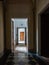 Vertical picture of a dark old corridor of a house with open doors