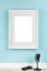 Vertical picture frame with matte mockup on turquoise wall with studio microphone and sunglasses