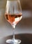 Vertical picture of glass of rose wine with reflection of old stone traditional provencal house in it. Rose wine in Provence,