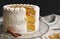 Vertical picture of a white delicious Christmas sliced cake with nuts and mandarine