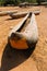 Vertical picture of wooden handmade canoes on the beach surrounded by greenery under the sunlight