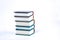 Vertical pile of books  on white background. Image contains copy space