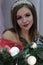 Vertical portrait of a beautiful girl in a red dress, against the background of NewYear`s decorations, looks into the camera