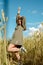 Vertical portrait of beautiful young woman in the field. girl in ears of wheat on summer field outdoors, fashion and model