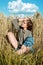 Vertical portrait of beautiful young woman in the field. girl in ears of wheat on summer field outdoors, fashion and model