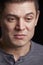 Vertical portrait of crying young white man looking down