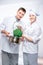 Vertical portrait of fellow cooks with saucepan and broccoli