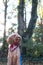 Vertical portrait of fluffy Labradoodle dog in red bandana saying & x22;Sophie& x22; licking his nose in park