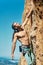 Vertical portrait handsome muscular man climber looking up with tense face and gripping hold