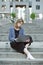 Vertical potrait of a concentrated young businesswoman working at her laptop. Bottle of water near the busy woman sitting on the