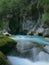 VERTICAL: Pristine stream flows along rocky riverbed of a beautiful gorge.