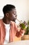 Vertical profile portrait of African American black man drinking healthy green juice with bamboo straw.