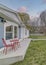 Vertical Puffy clouds at sunset Front yard of a house with concrete deck and white wooden fence