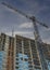 Vertical Puffy clouds at sunset Low angle view of an unfinished building with tower cranes at Sa