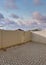 Vertical Puffy clouds at sunset Vinyl fence of a backyard with bricks in herringbone pattern